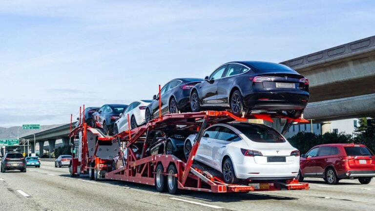 Open car carrier trailer stacked with cars on an open road